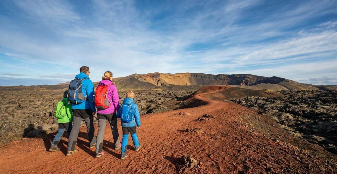 Une famille avec jeunes enfants explorant le paysage volcanique lunaire de La Réunion sous un ciel bleu azur