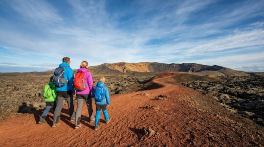 Une famille avec jeunes enfants explorant le paysage volcanique lunaire de La Réunion sous un ciel bleu azur